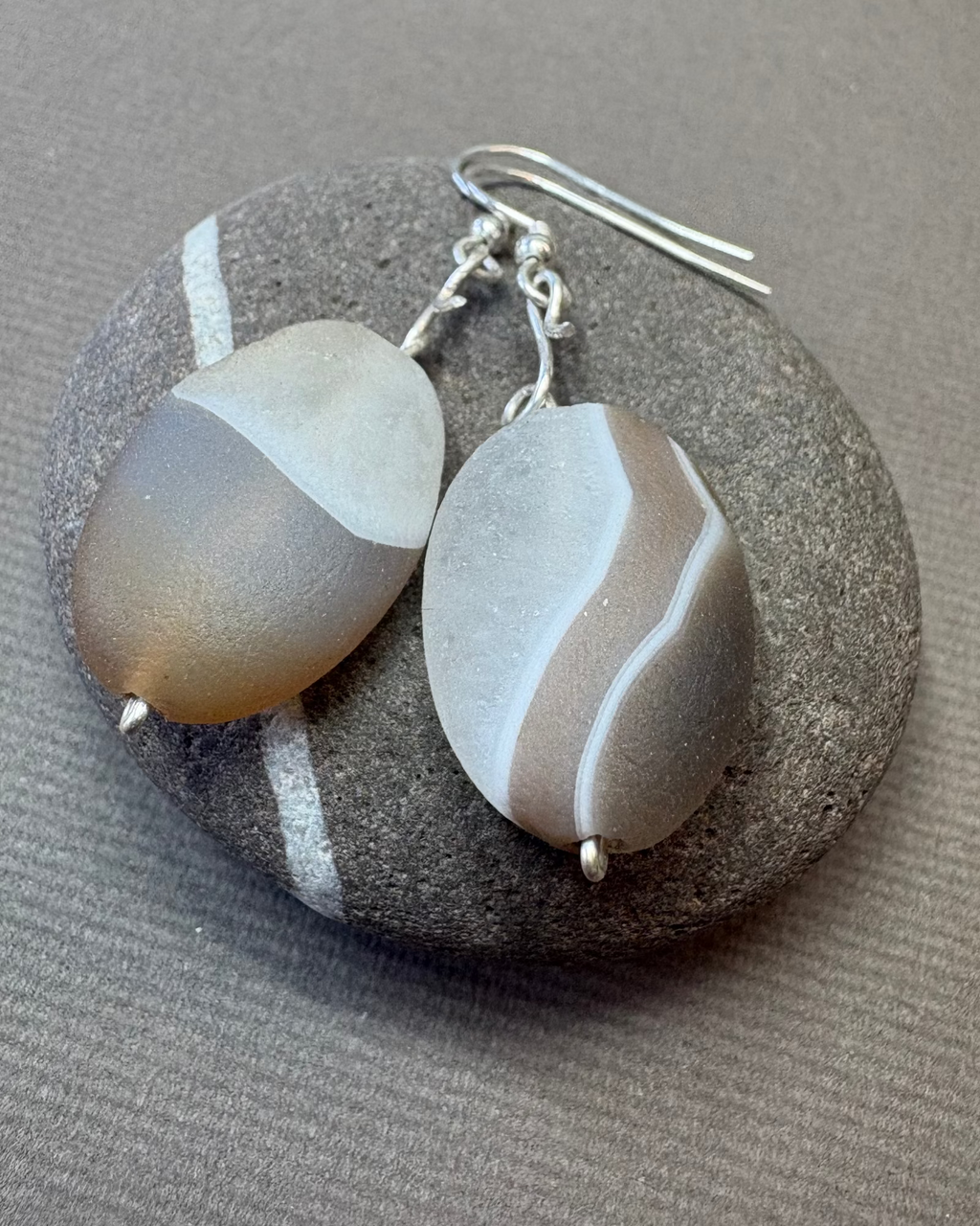 Pair of agate geode earrings on a stone surface