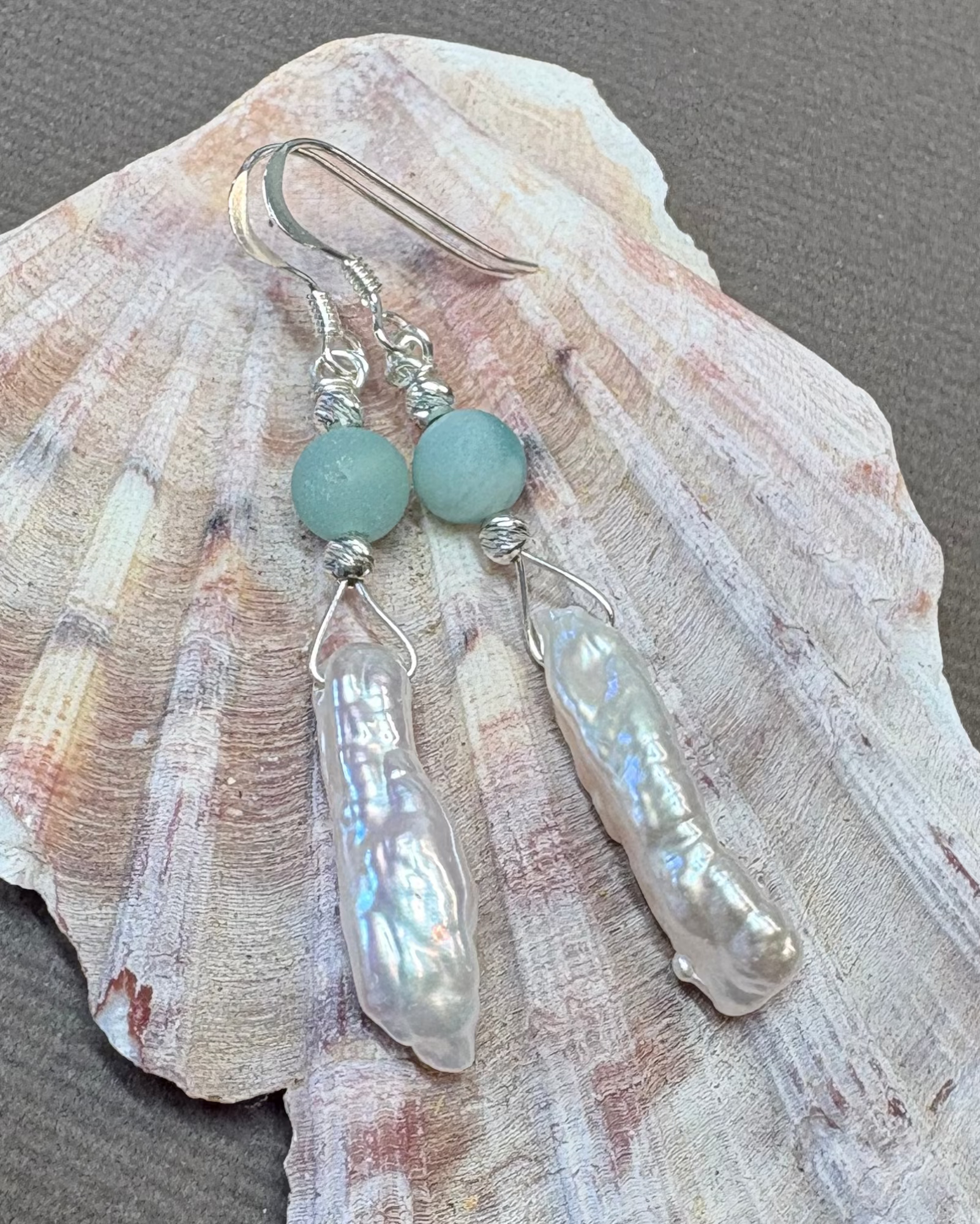 Pearl and silver earrings with green agate beads on a shell 