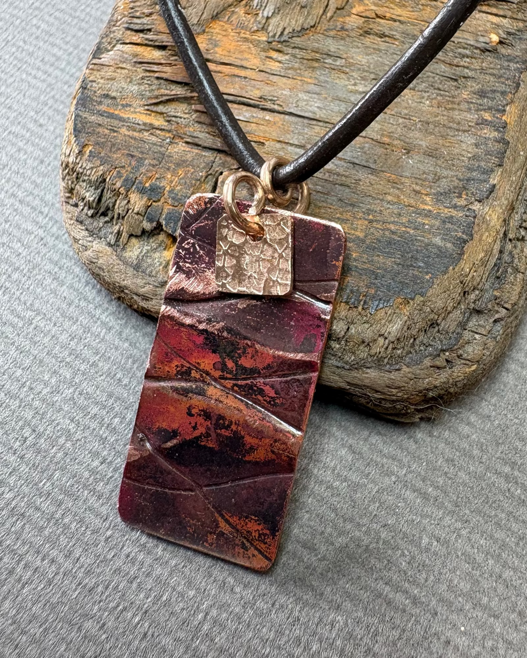 Oxidised Copper pendant necklace on a driftwood block