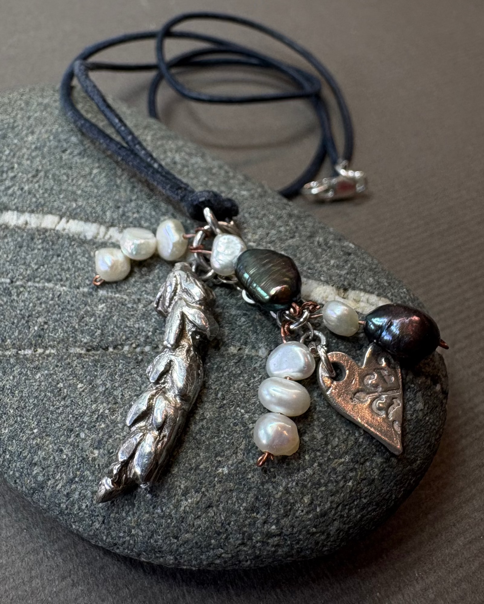 Silver lavender and heart with pearls charm nexklace on black leather cord on a pebble