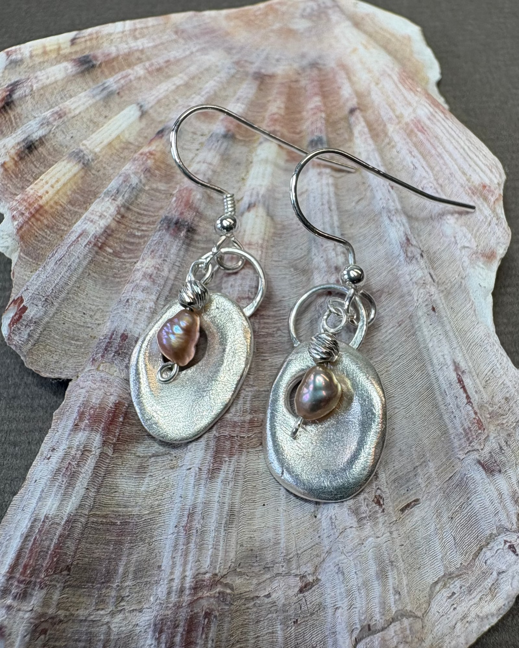 Silver holey shell earrings with pearl  beads on a shell