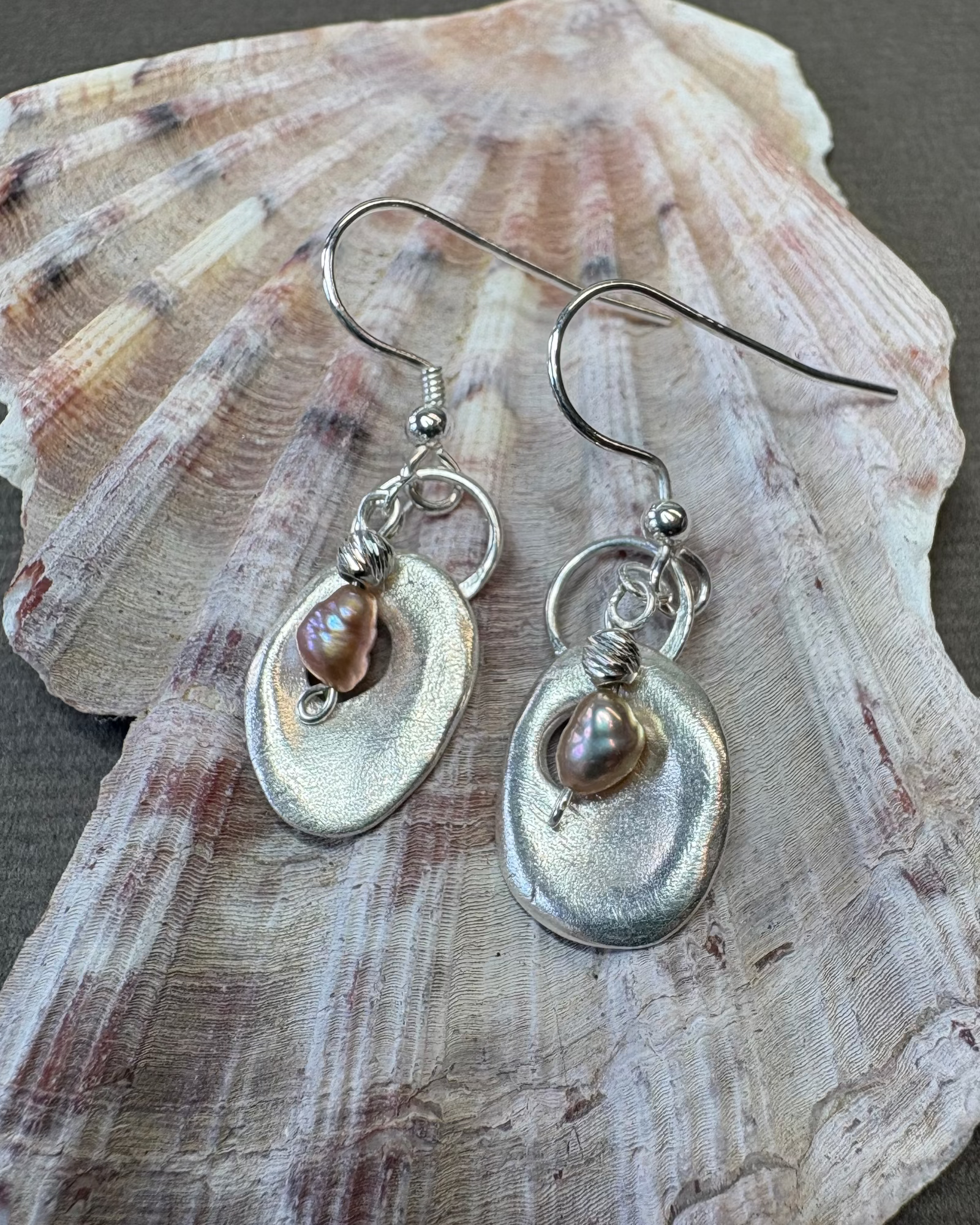 Silver holey shell earrings with pearl  beads on a shell