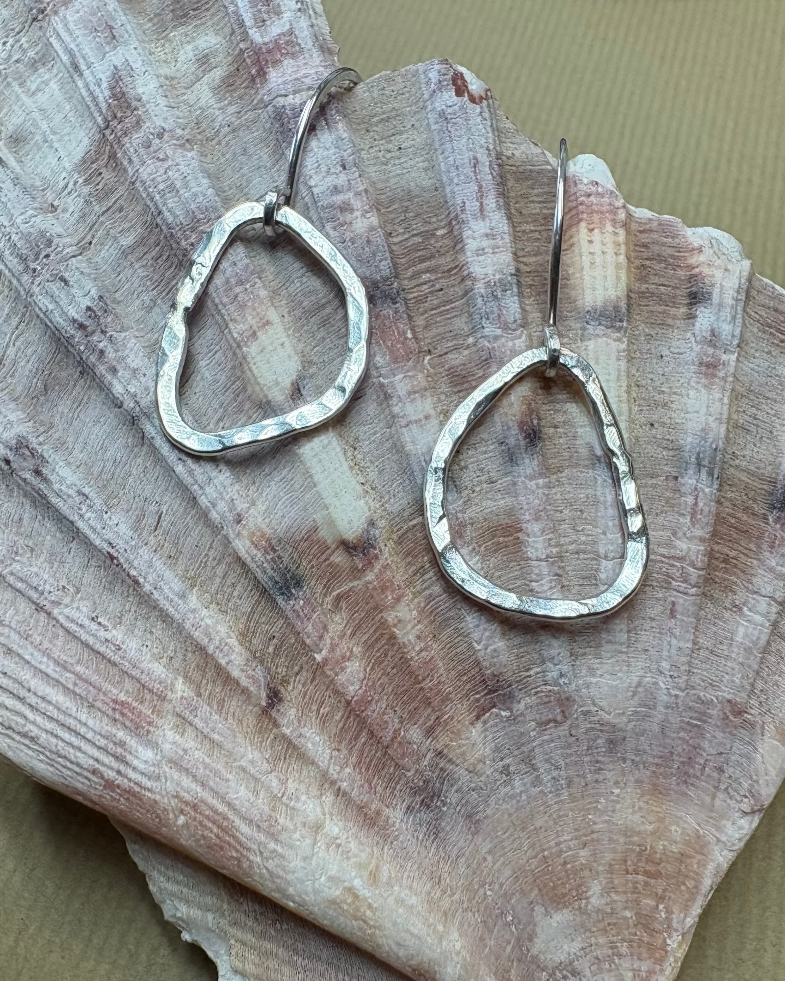 Silver hammered earrings on a large shell 