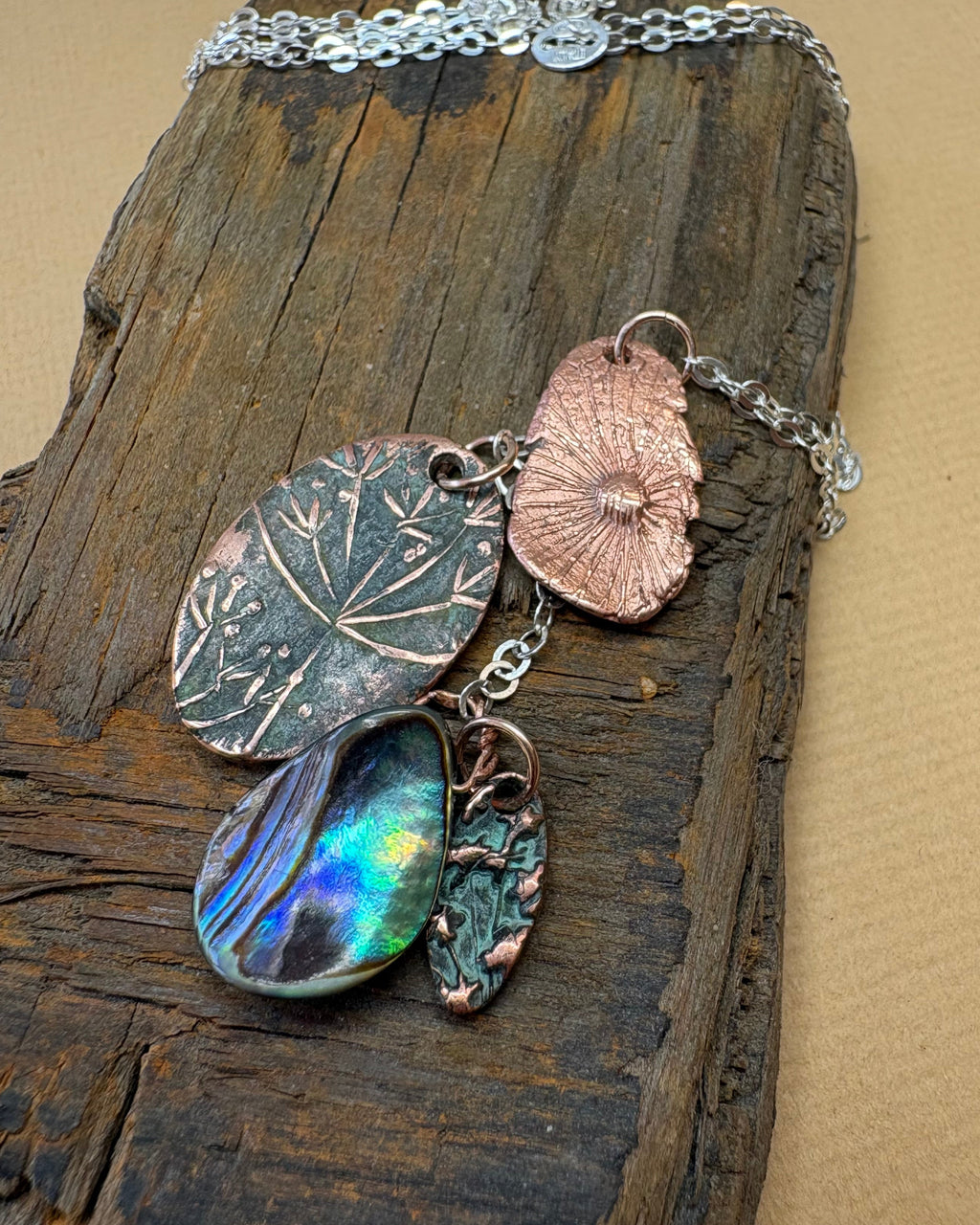 Necklace with flower texture and papa shell charms pendant on a wooden surface
