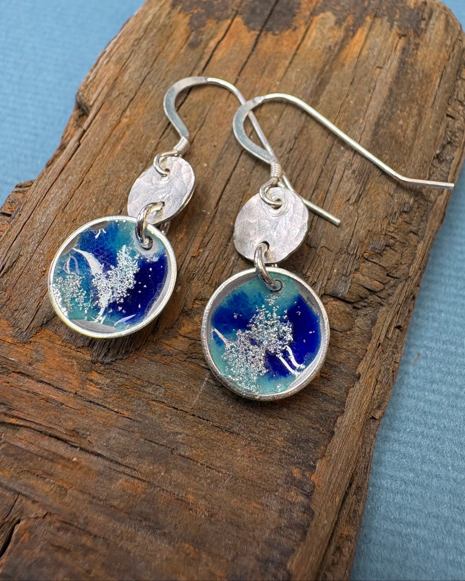 round silver concave enamel disc earrings with blue, aqua and silver to look like pools, with second hammered silver circle disk above, hung on silver ear wires